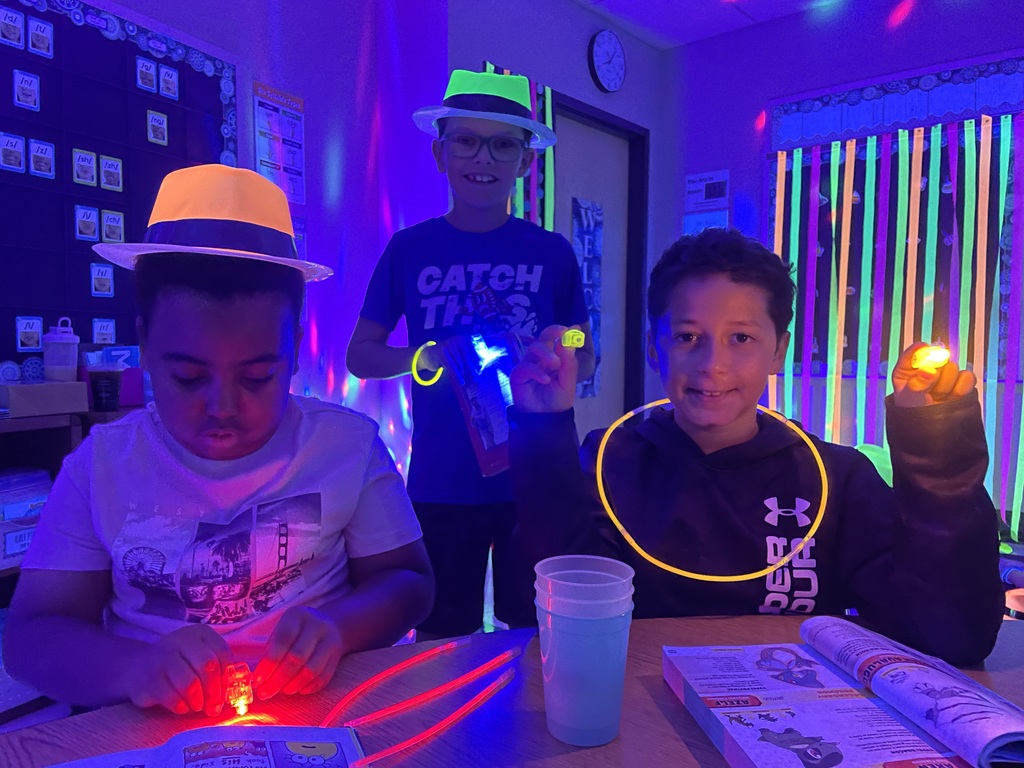 Students reading with glow in the dark finger lights