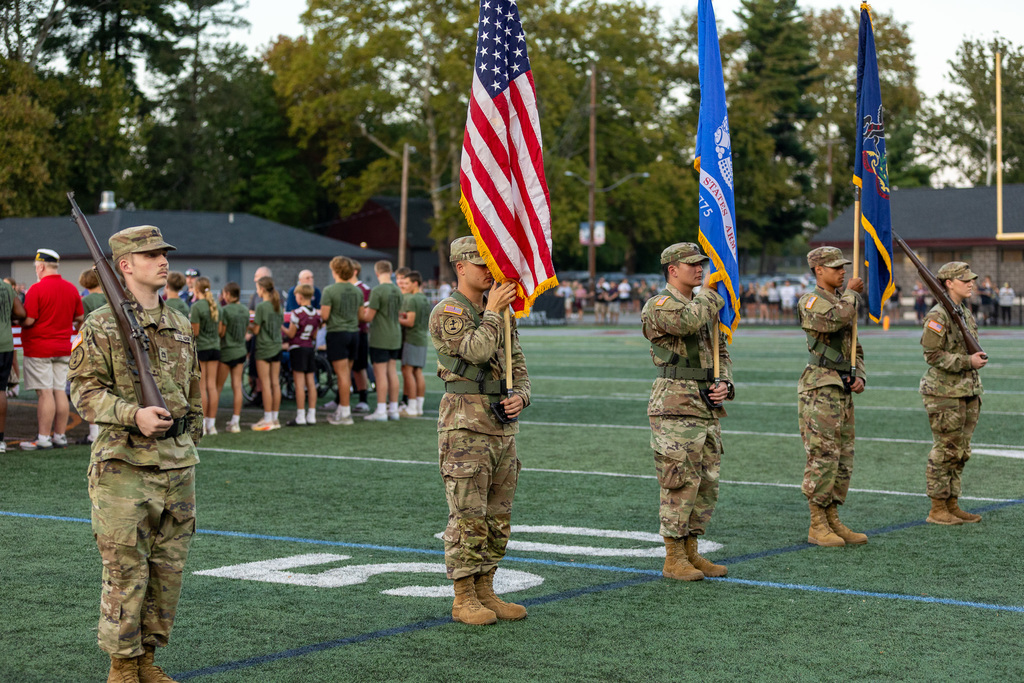 Military personnel presenting the colors.