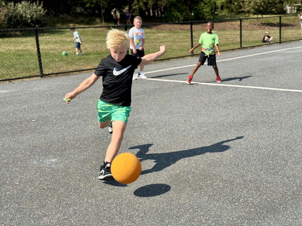 A young boy plays kickball at recess.