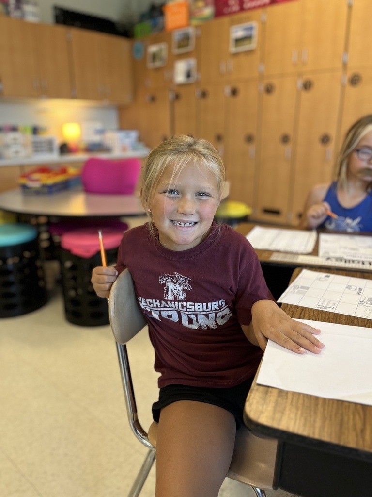 A young student wearing a maroon school shirt.