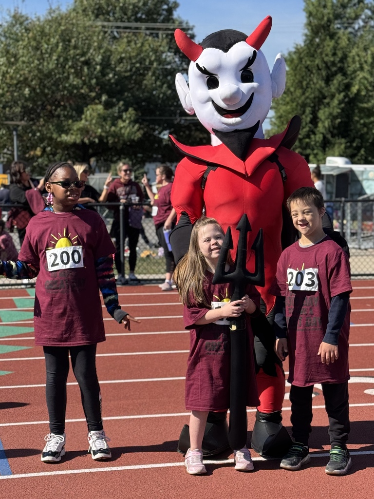 Young special olympians standing with a college mascot dressed like a red devil.