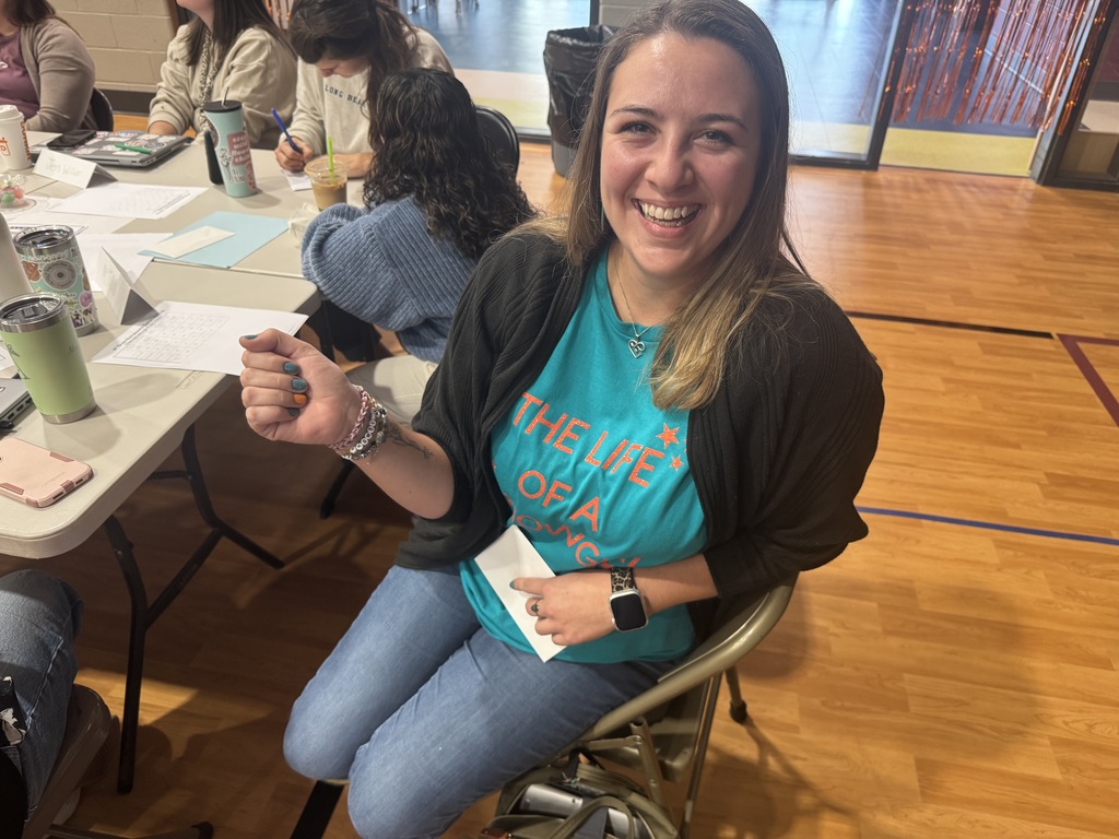 A staff showing off her wildcat inspired taylor swift bracelet.