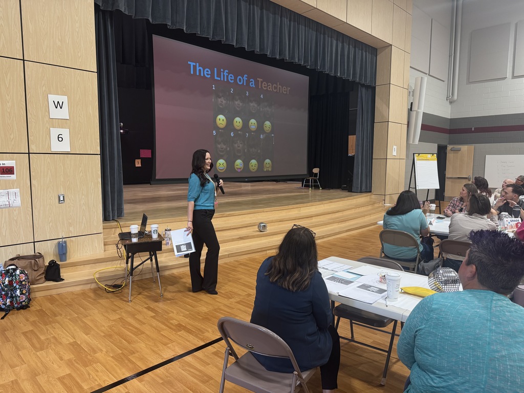 Teacher stands in front of screen that says Life of a teacher.