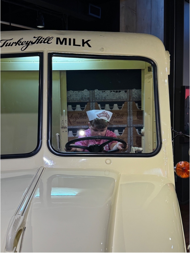 Student driving a pretend milk truck