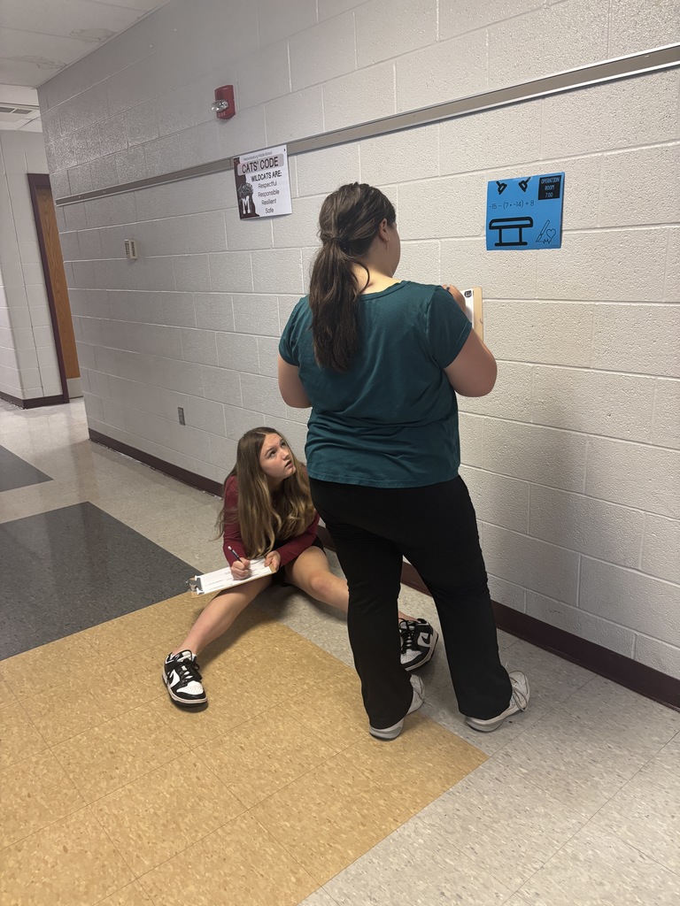 Students in hallway working on a math problem