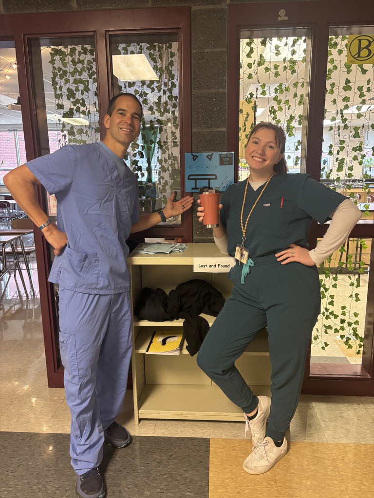 Two teachers wearing scrubs for a medical math class project