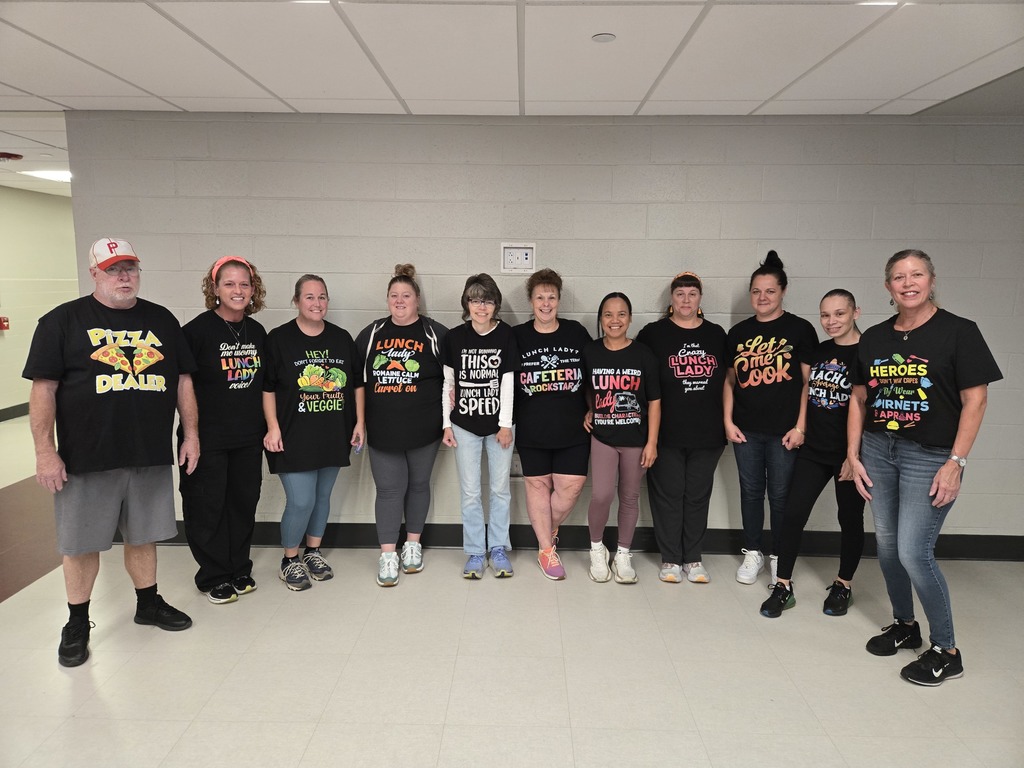 A group of staff standing together in humourous food service tshirts.