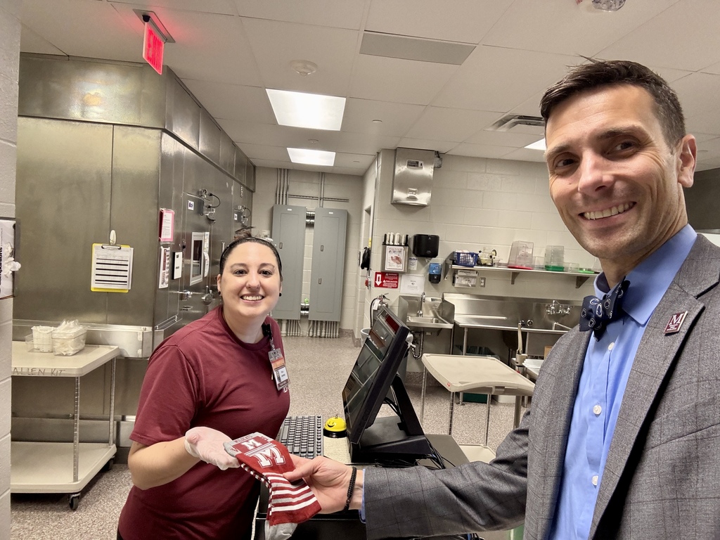 An adult male presenting branded socks to a female staff member.
