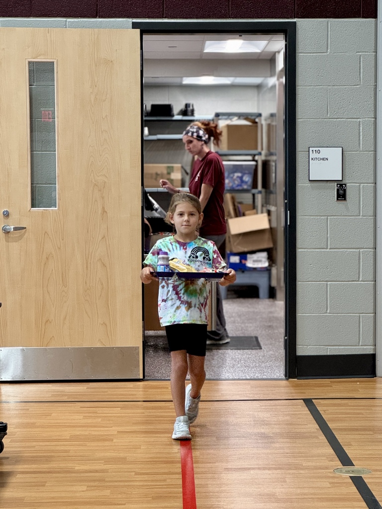 A student carrying her lunch tray out of the cafeteria.