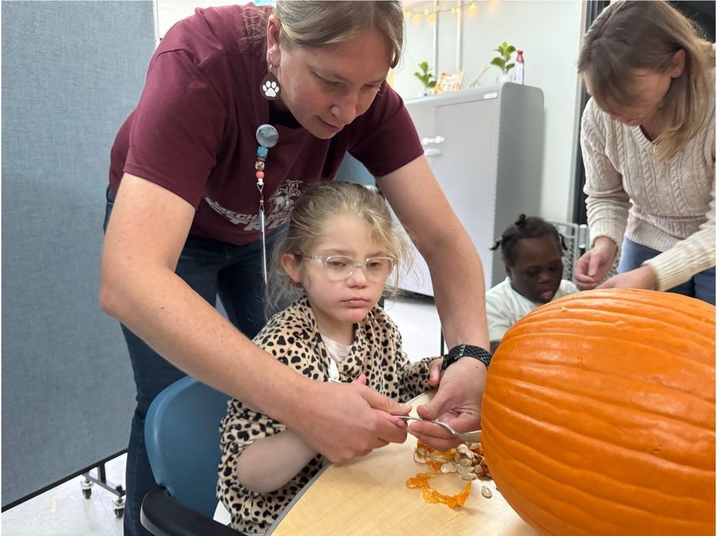photo of student exploring  a cut pumpkin