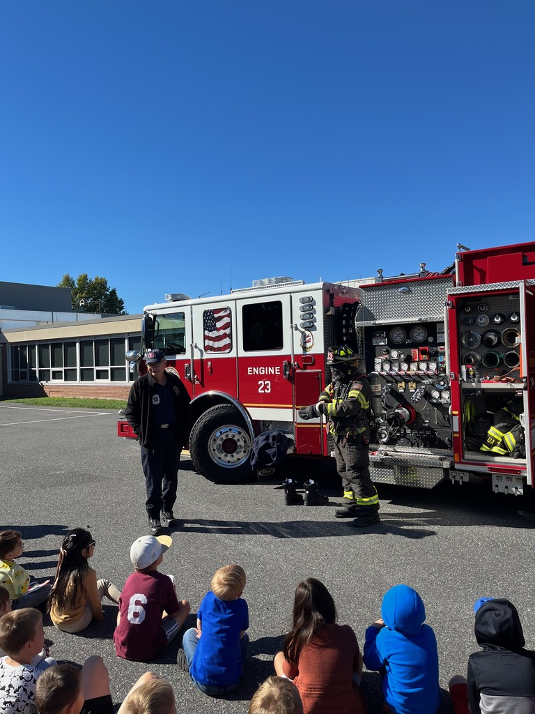 Elementary students looking at fire apparatus.
