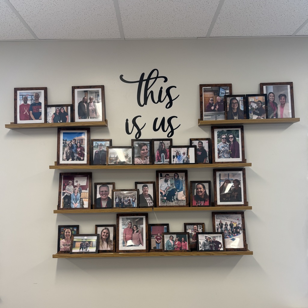 Display of photos on the wall of a faculty room.