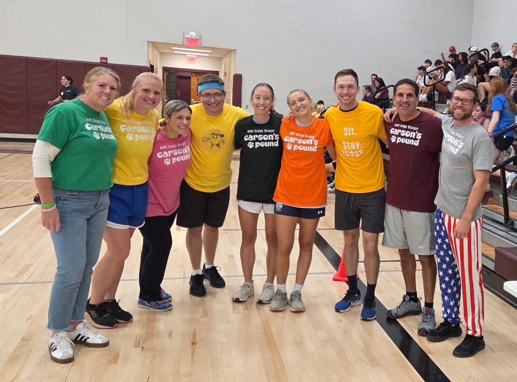 A group of adults standing together in colorful "Carson's Pound" tshirts.