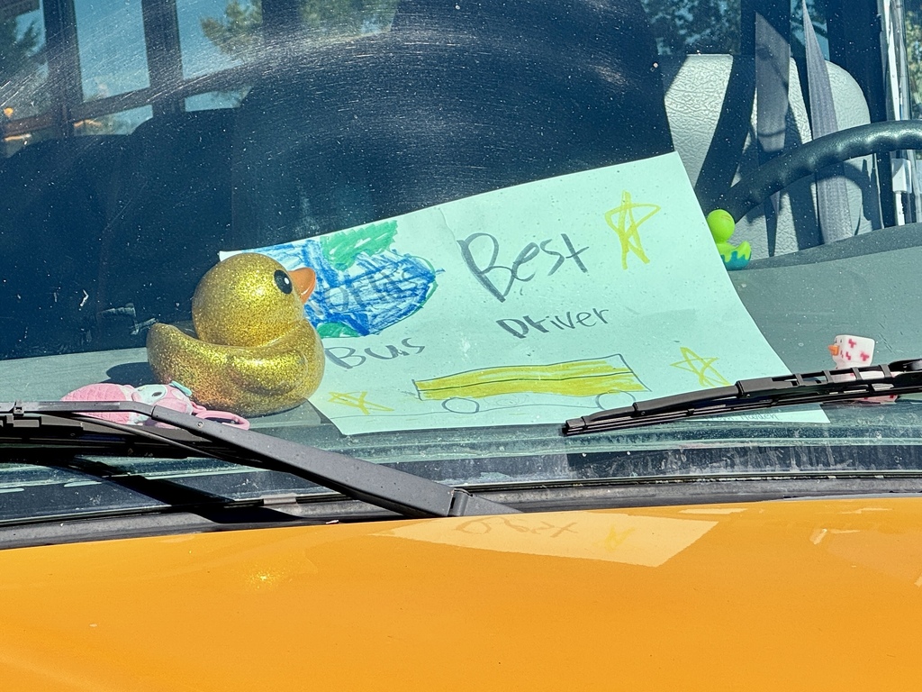 A "World's Best Bus Driver" sign proudly displayed on the dashboard of a school bus.