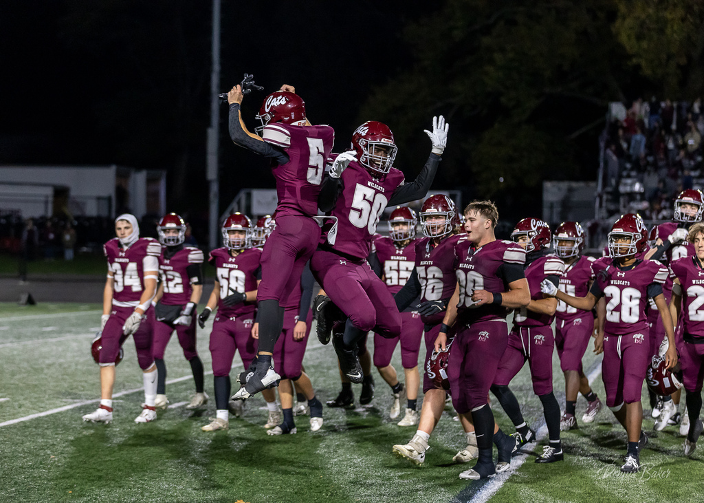Football players on the field celebrating a win