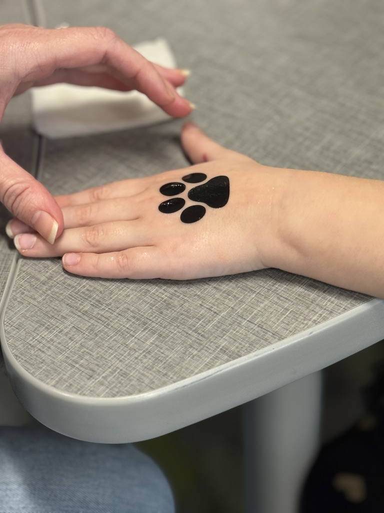 A student getting a temporary tattoo of a paw print.