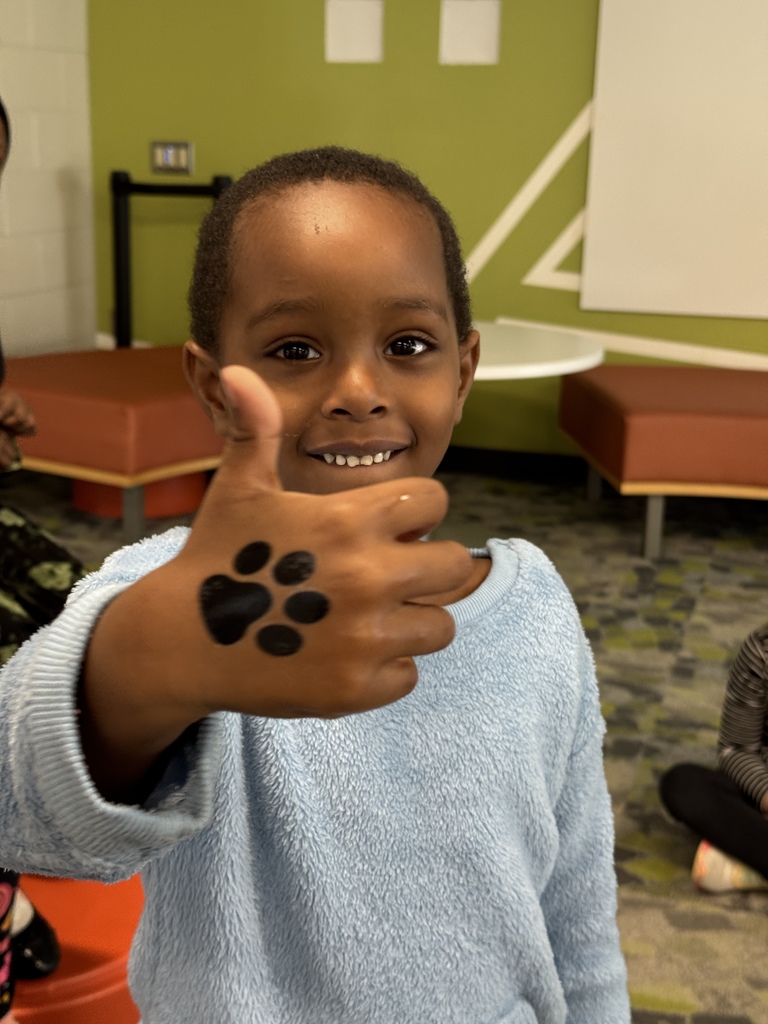 A student showing a temporary tattoo of a paw print.