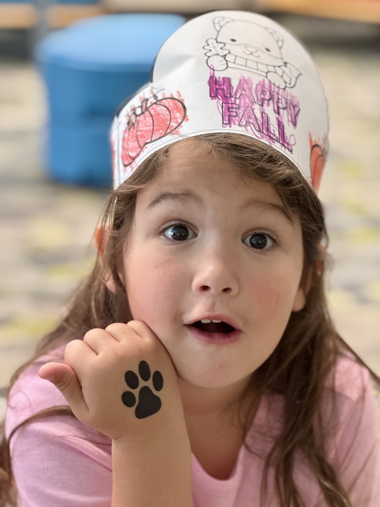 A student showing a temporary tattoo of a paw print on her hand.