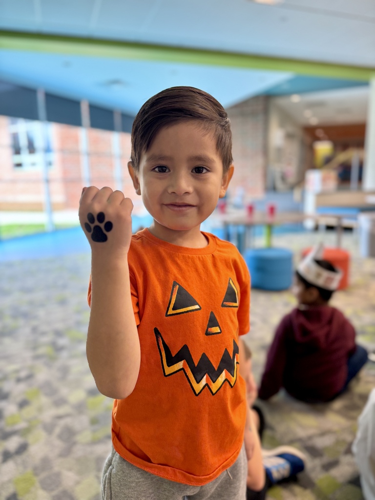 A student showing a temporary tattoo of a paw print on his hand.