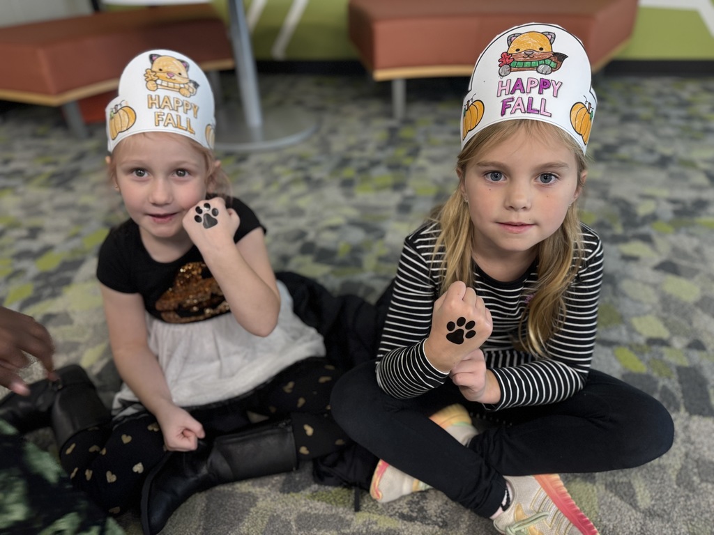 Students showing a temporary tattoo of a paw print on their hands.