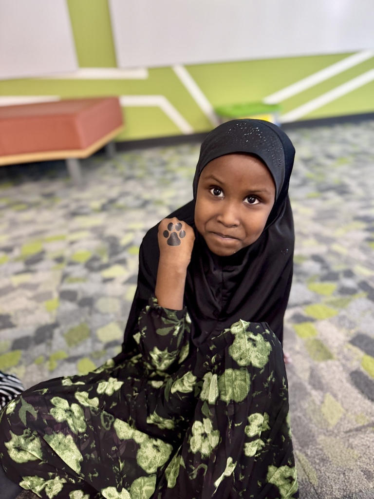 A student showing a temporary tattoo of a paw print on her hand.