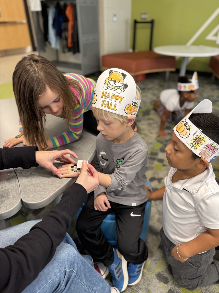 A student getting a temporary tattoo of a paw print.