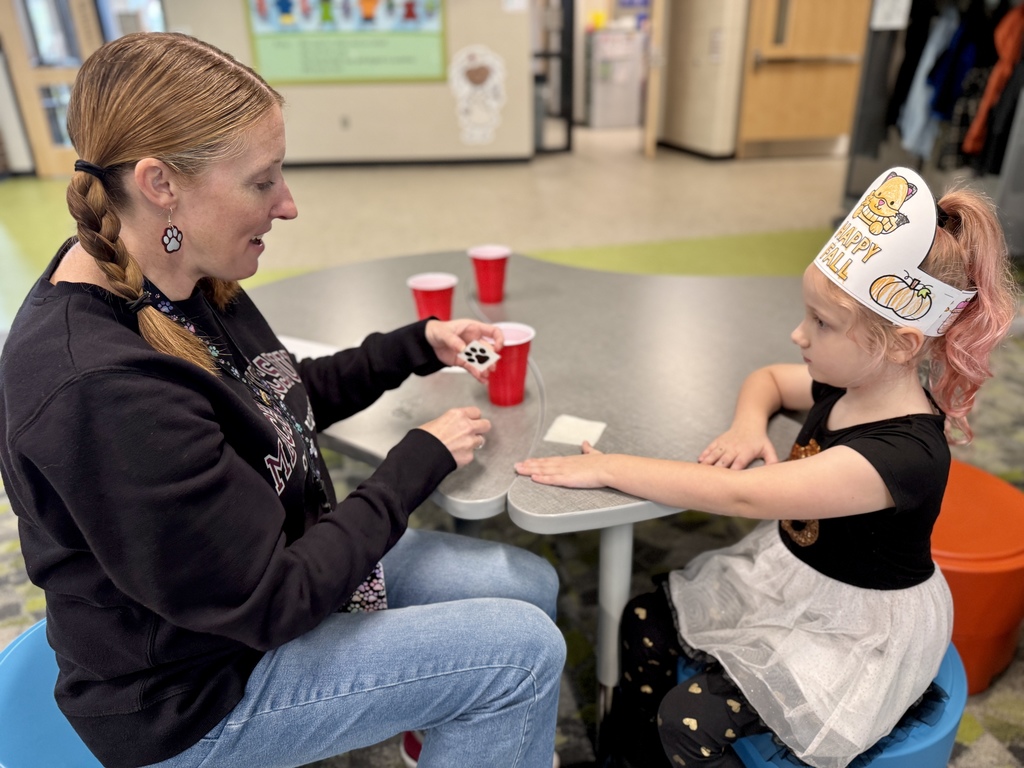 A student getting a temporary tattoo of a paw print on her hand.