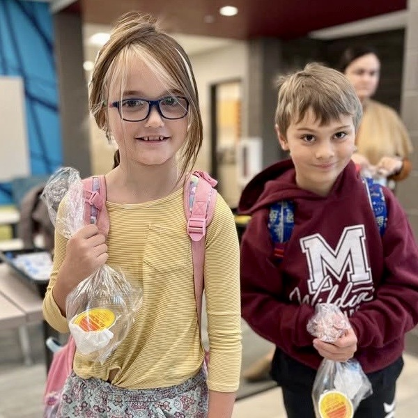 a young girl and boy pick breakfast items