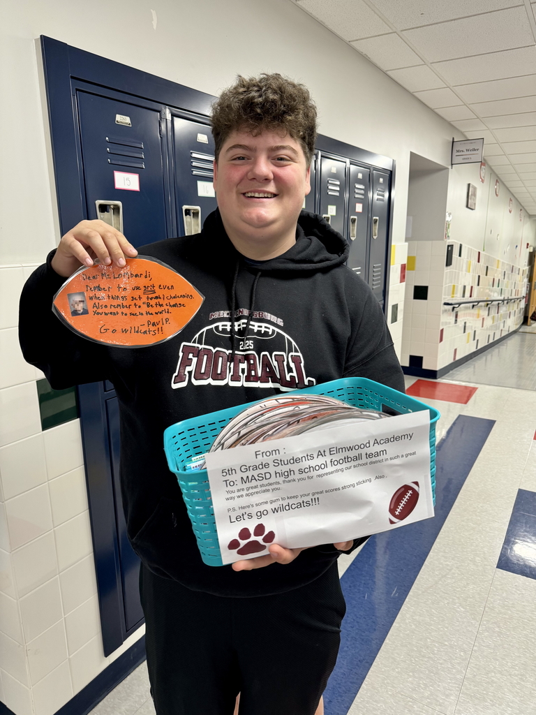 A football player holding a handwritten message from a young student.