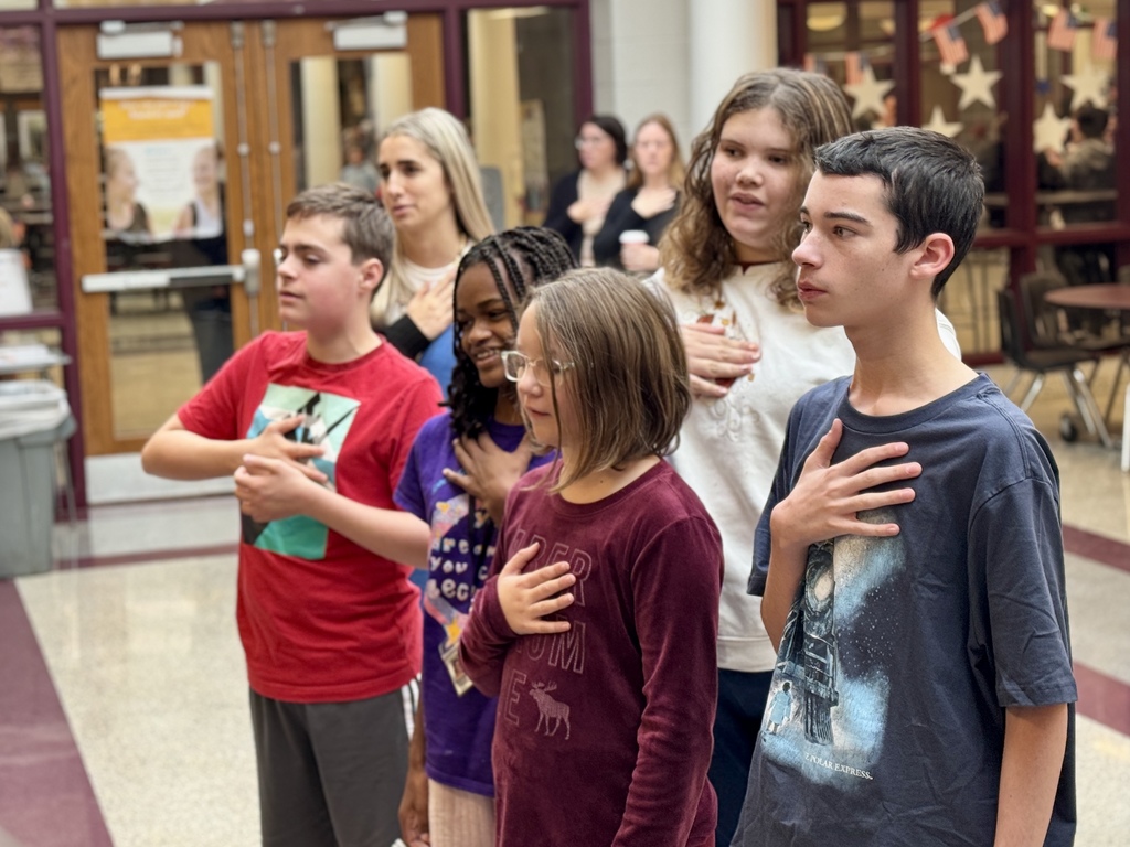 Students with hand over heart, reciting the Pledge of Allegiance.