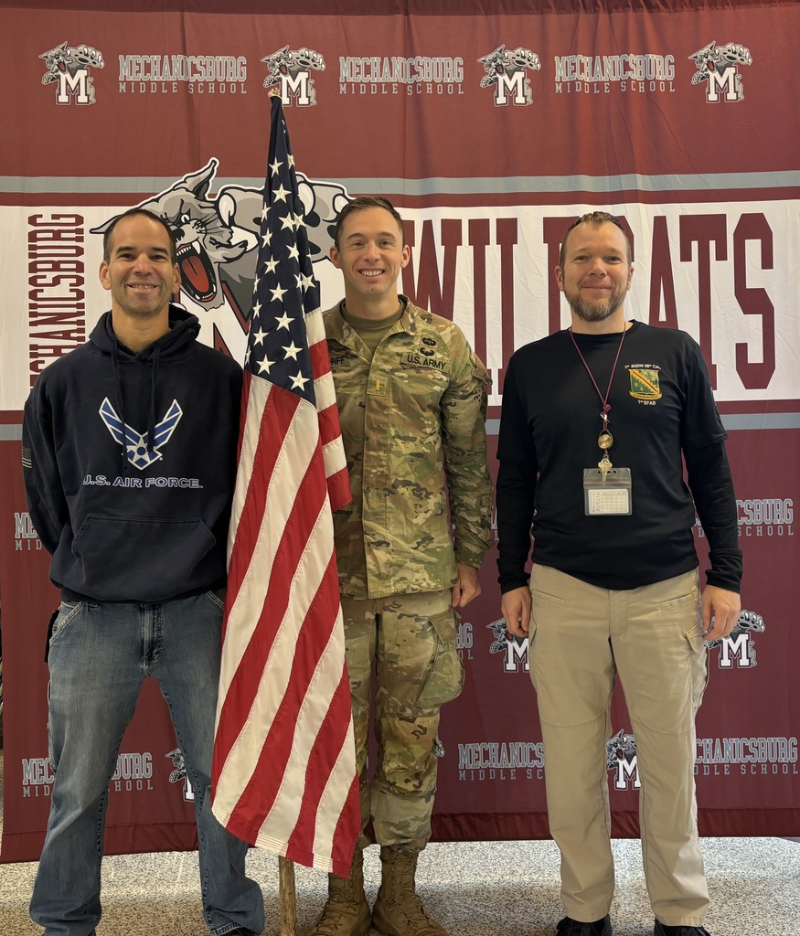 Three teachers who are also veterans standing with an American flag.