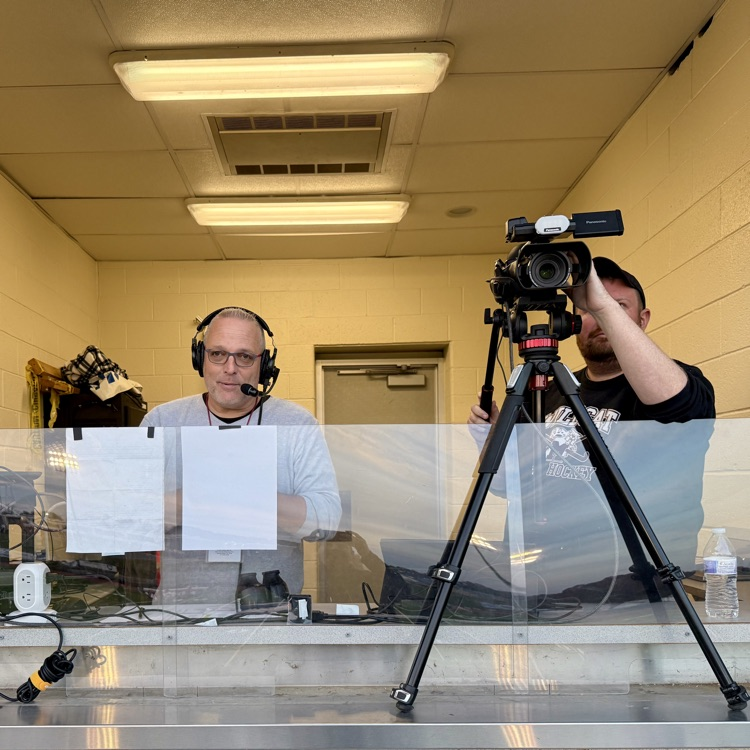 two men in a broadcast booth recording a sporting event