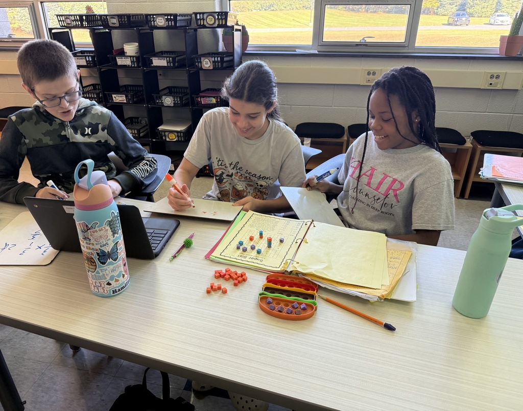 Three students playing a game in math to help learn fractions.