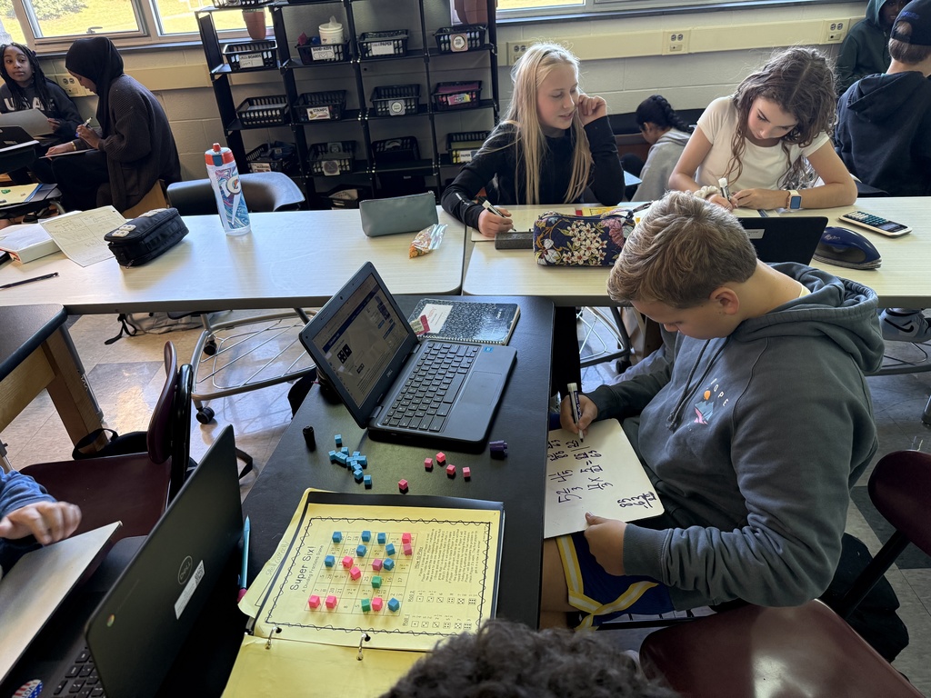 Three students playing a game in math to help learn fractions.