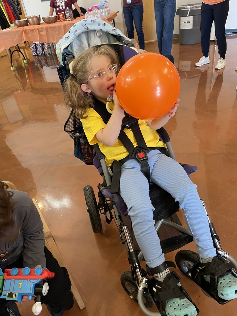 A student in a wheelchair with an orange balloon.