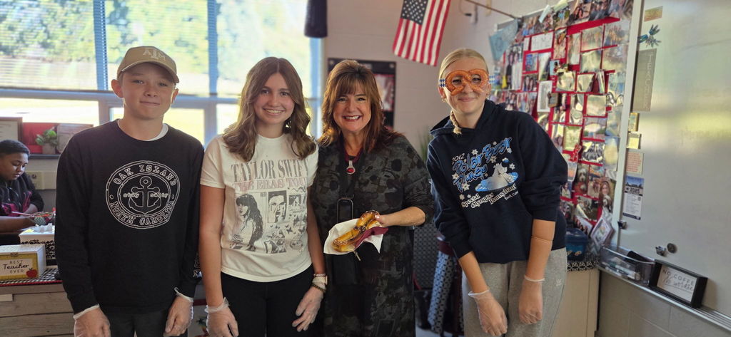 Students with a teacher who is holding a soft pretzel