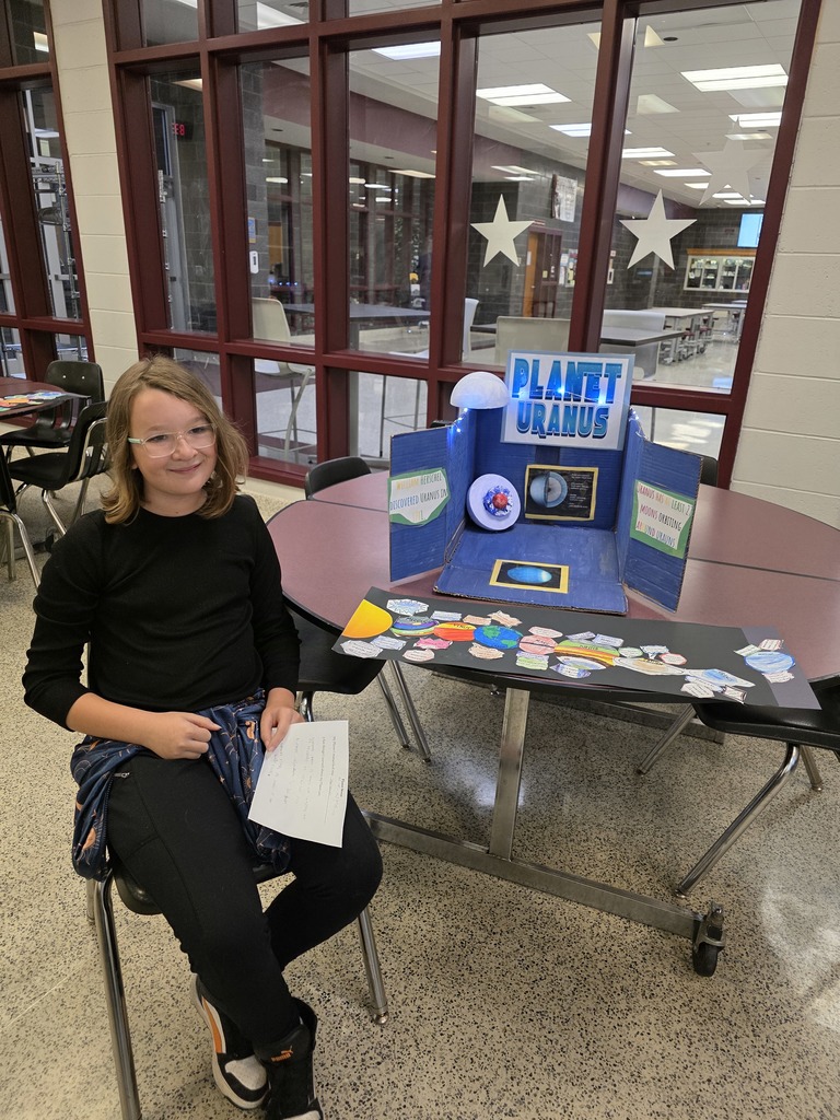 A student showing a solar system display.