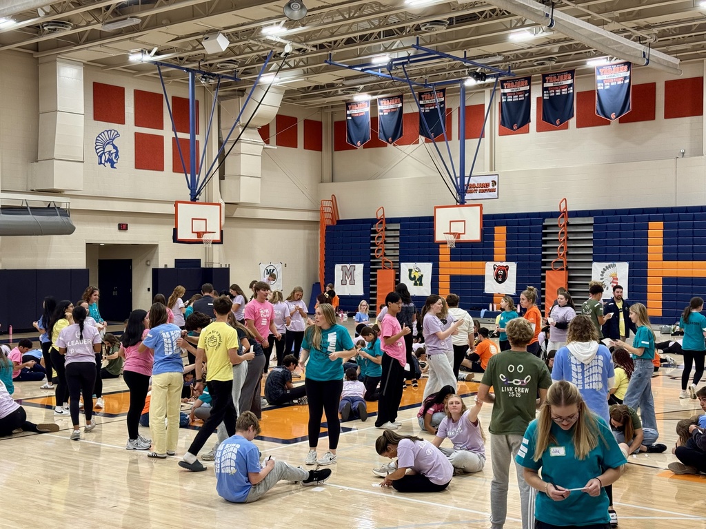 A large group of students gathered in a high school gym.