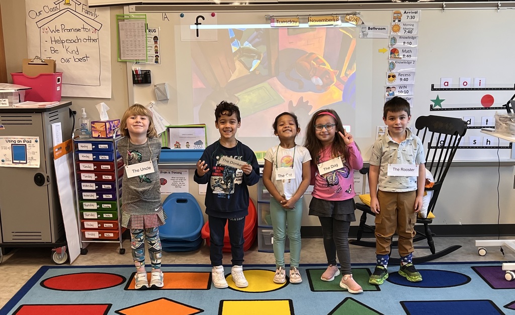 Group of young students standing on a kindergarten classroom carpet.
