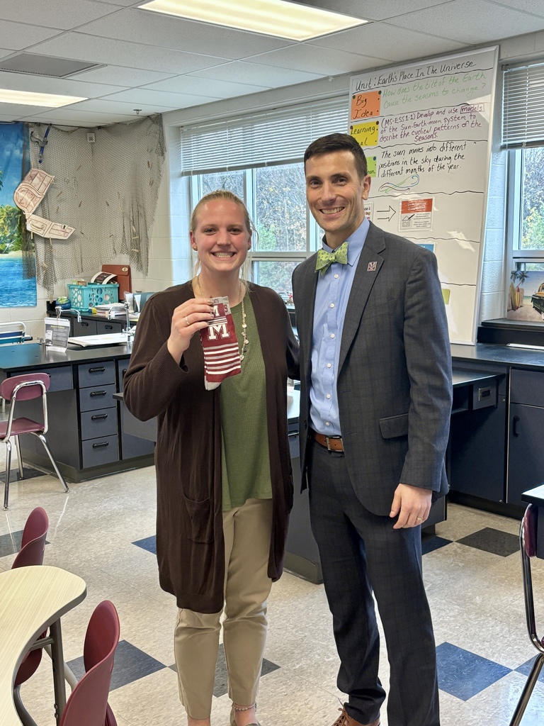 A man presenting a pair of branded socks to a staff member.