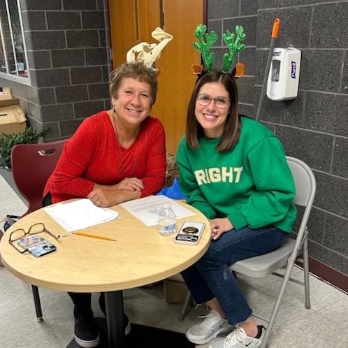 Two volunteers sitting at a table.