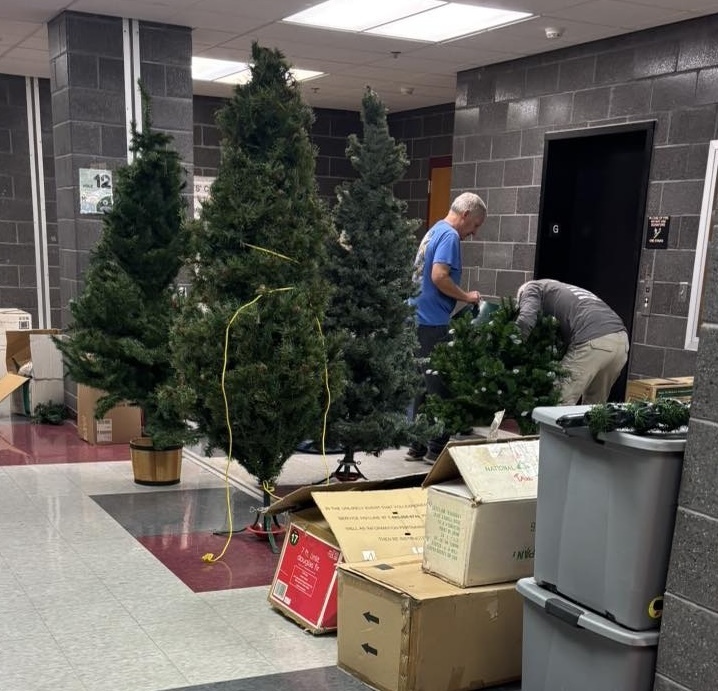 Two men sorting artificial holiday trees.