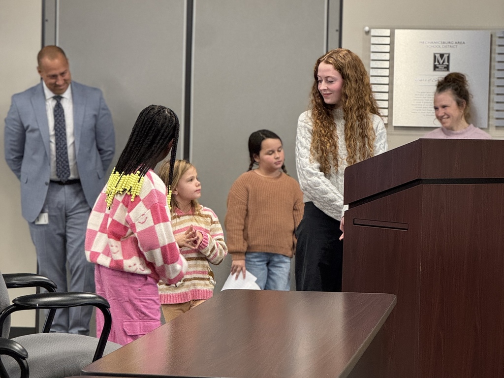 Students talking in front of a school board.