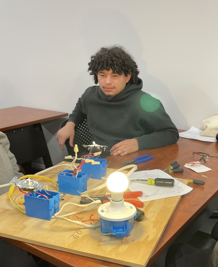 A student wires a lightbulb during a career exploration event.