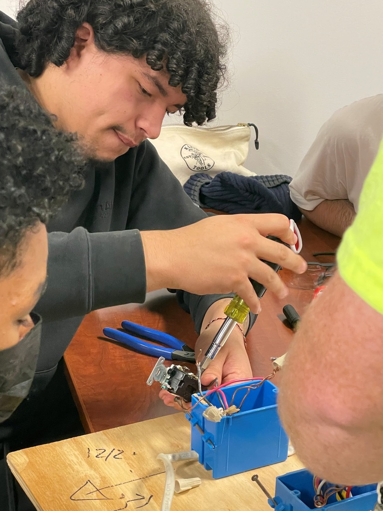 A student wires a lightbulb during a career exploration event.