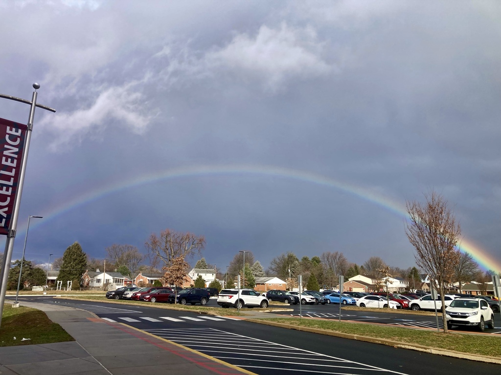 A rainbow over a parking lot.
