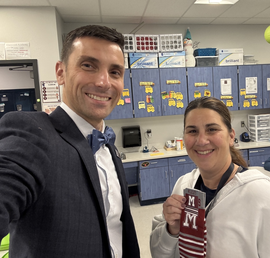 A teacher holding a pair of branded socks presented to her by the superintedent.