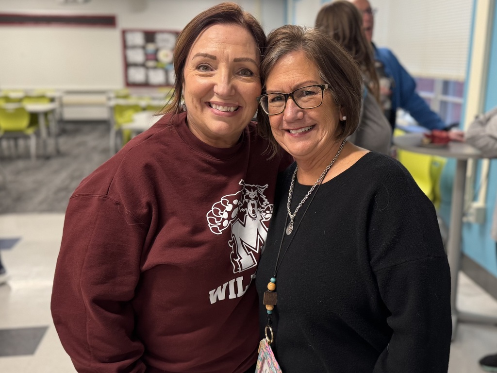 Two teachers standing beside each other to celebrate a retirement.