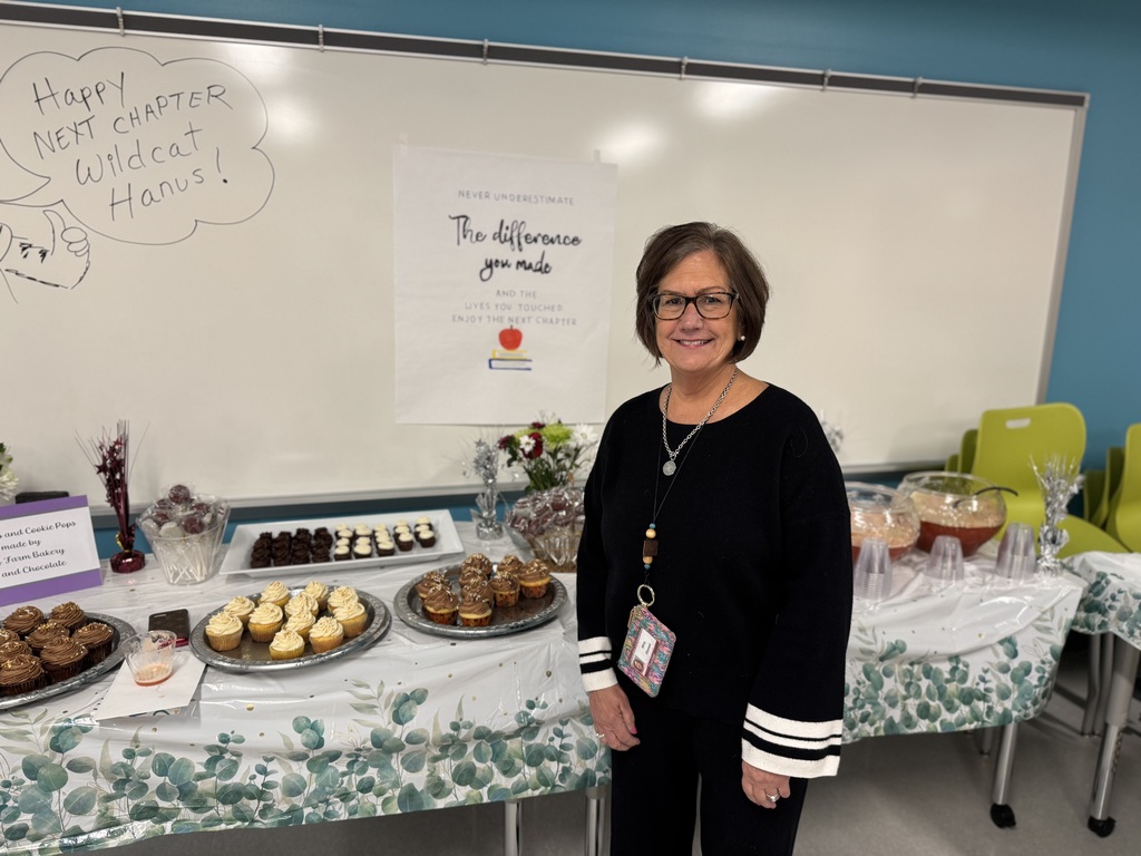 A teacher standing in front of a table to celebrate her retirement.