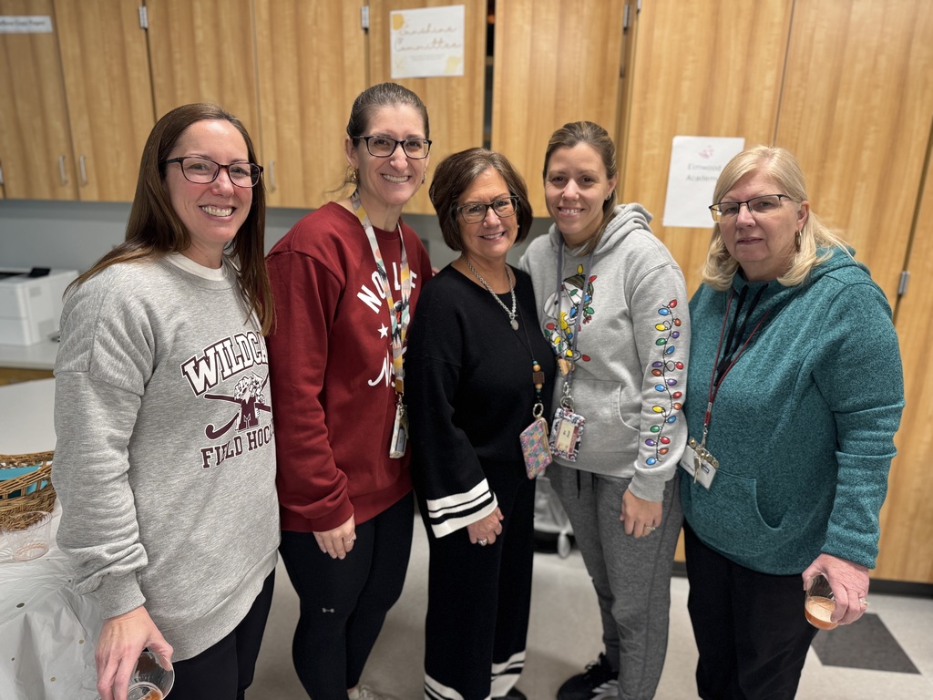 A group of teachers standing together to celebrate a colleague's retirement.